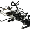 A bare-bones go-kart chassis with a steering wheel, steering column, and brake system components, without an engine or wheels, displayed on a white background.