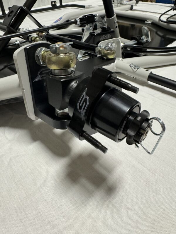Close-up of the Foot Pan component for Elevate, Pursuit & Xpect CHAMP KART, featuring a black and white assembly with bolts and a fastening mechanism on a white background.
