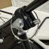 Close-up of the metal hardware on a black pole, showcasing the bolted attachment with a securing cable and pin on the Foot Pan for Elevate, Pursuit & Xpect CHAMP KART.