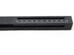 A close-up image of a black rectangular measuring tool with a slot and markings numbered from 12 to 22.
