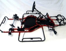 Go-kart chassis with a red metallic frame, steering wheel, and basic components on a white background.