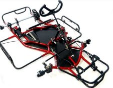 An overhead view of a bare go-kart chassis with red and black metal framing, steering column, and mounting points for additional components.